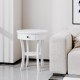 Round white end table with open drawer and shelf, made of MDF, perfect as a bedside or snack table in any decor.